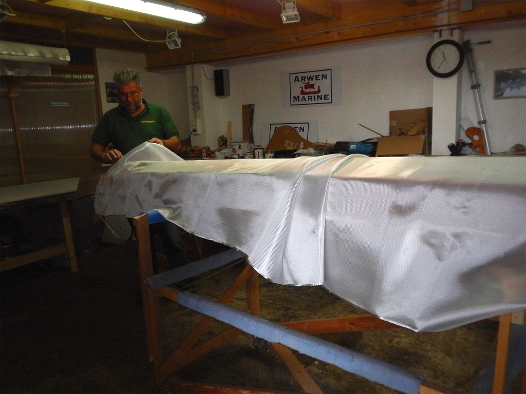 Nous drapons le tissu de verre sur la coque en éliminant au maximum les plis. 