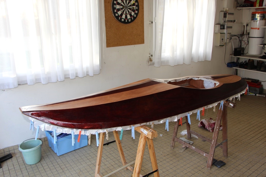 Didier nous envoie les quatre images suivantes du Matunuck Surf Kayak qu'il a construit cet automne et vient d'essayer. Cette première image montre la stratification du dessus. Le poids des pinces à linge suffit à maintenir une tension suffisante sur le tissu de verre saturé d'époxy afin qu'il reste plaqué sur les cotés. 
