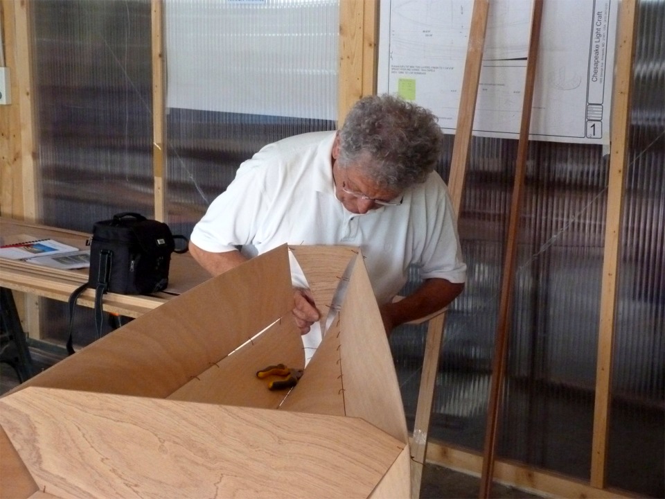 Pierre passe les sutures en fil de cuivre qui vont connecter le tableau arrière aux panneaux latéraux et de fond. 